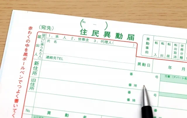 Image of a person filling out moving notification forms (Tensusu Todoke and Tennyū Todoke).