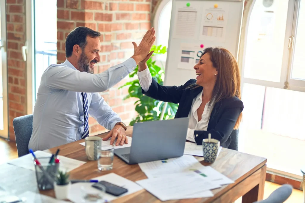 Image of a business handshake with a sign that says 'Win-Win,' symbolizing mutual benefit.