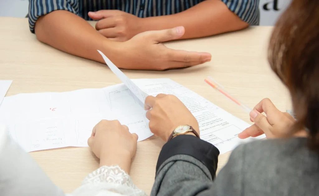 Image of a business person writing on a document, symbolizing a draft or early version.