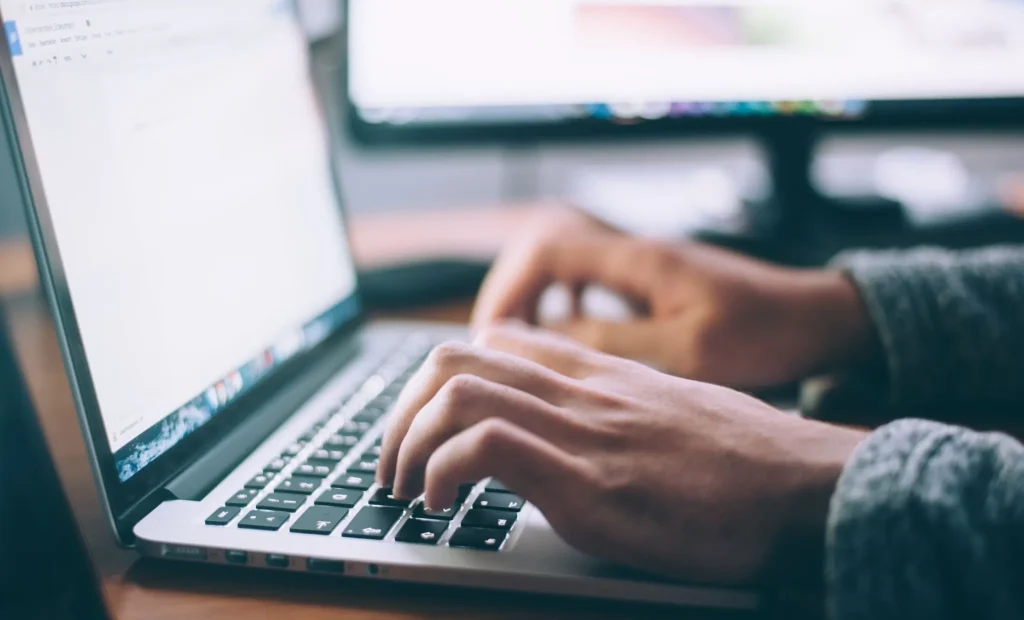 Image of a person using a laptop to search for a shared apartment online.