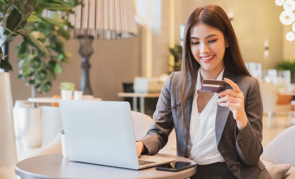 Image of a woman happily using a debit card for a transaction.