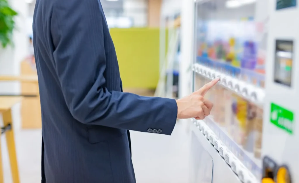 Image illustrating the steps for buying a drink from a Japanese vending machine.