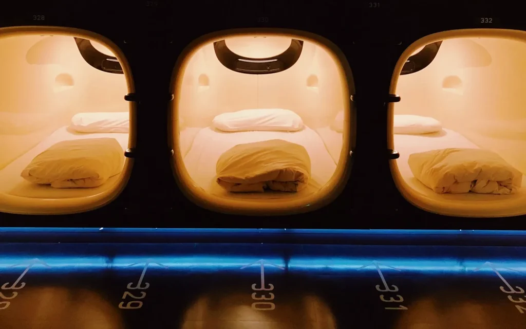 Image showing the interior of a capsule hotel with rows of sleeping compartments.