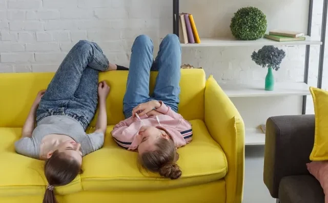 Image of friends enjoying a meal in a shared apartment kitchen, suggesting the intimacy of room sharing.