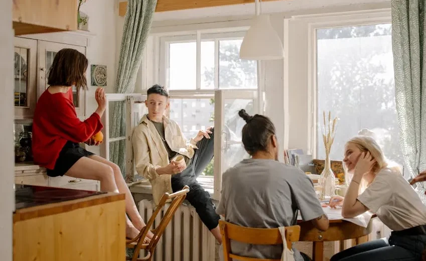 Image showing a group of young people socializing in a bright, modern share house in Okinawa.