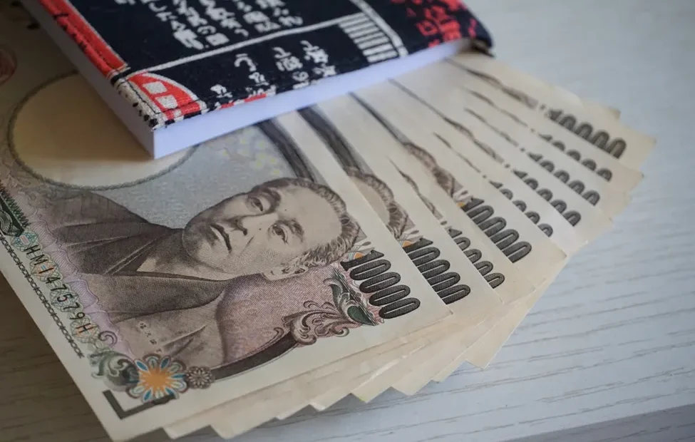 Image showing Japanese language school materials and a calculator, emphasizing the financial aspect of studying.
