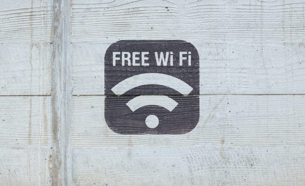 Image of a foreign man checking his phone for Wi-Fi availability in a Japanese public area.