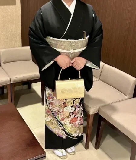Image of a woman wearing a formal Kuro-tomesode kimono, which is black with patterns only on the lower hem.