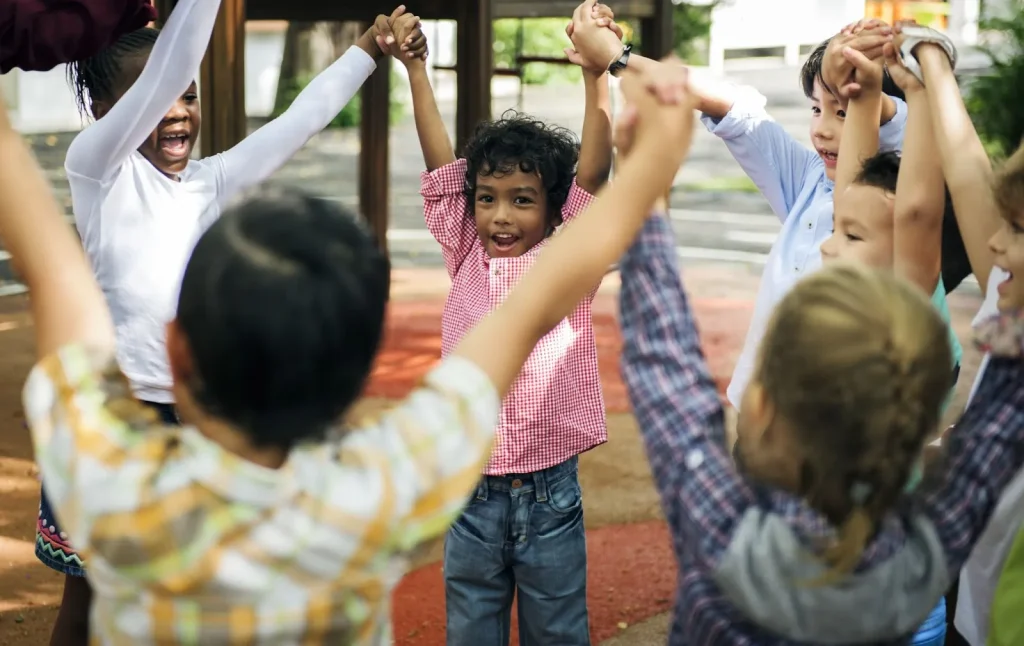 Image of young children in a circle with a teacher in a bright, modern classroom.