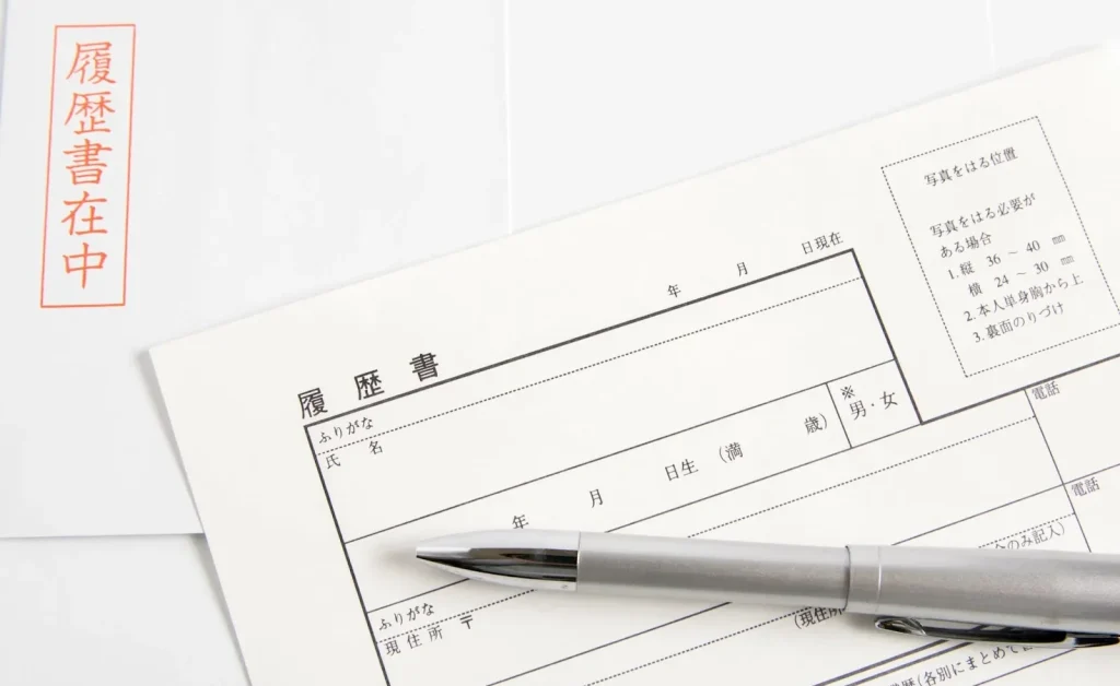 Image of a foreign man and a Japanese woman conducting a formal interview at an office desk.