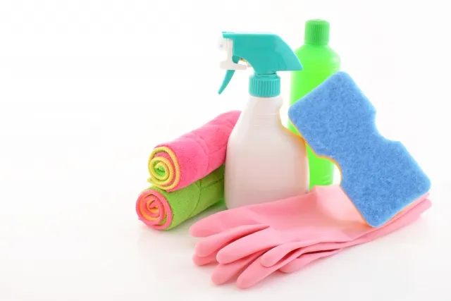 Image of a woman cleaning a modern kitchen counter, illustrating professional housekeeping service.