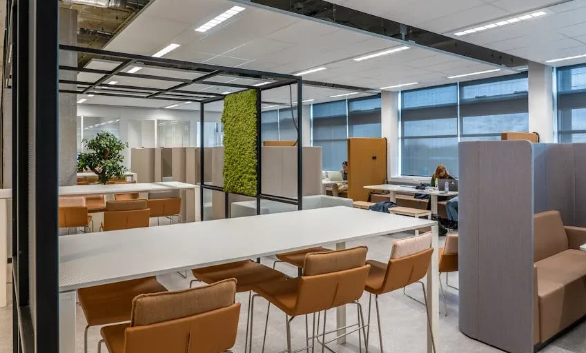 Image illustrating a modern, well-lit co-working space with people working at desks and in meeting areas.