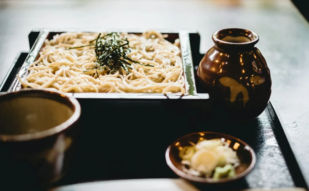 Image of a traditional Japanese food item (probably Onigiri) and miso soup, symbolizing local Asakusa cuisine.